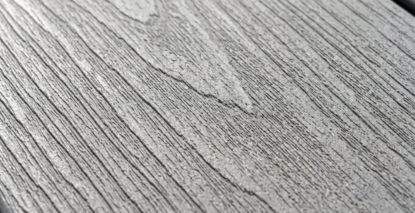 Gros plan sur la texture et le grain d'une lame de terrasse en composite moderne avec détails de la finition lisse